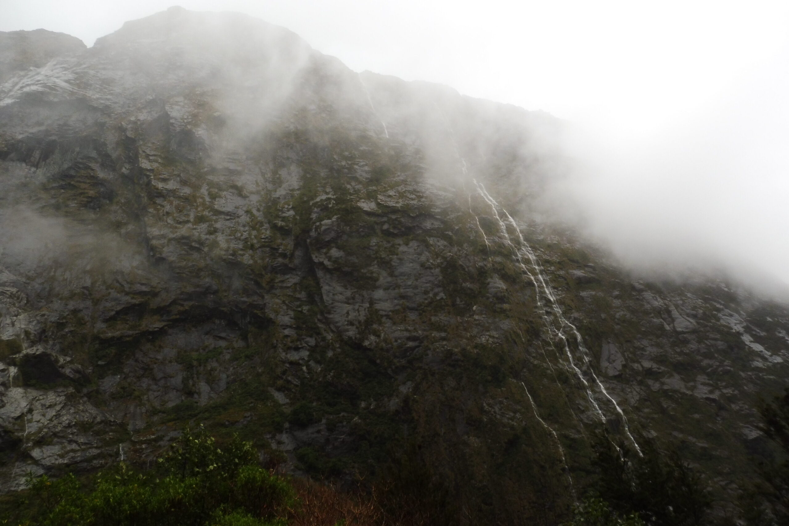 Misty mountain cliffside with dense fog in New Zealand. Marketing services. Captured by JSMS.